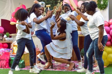 Joyful bridal party with friends gathering for bachelorette celebration outdoors, filled with laughter and playful antics.