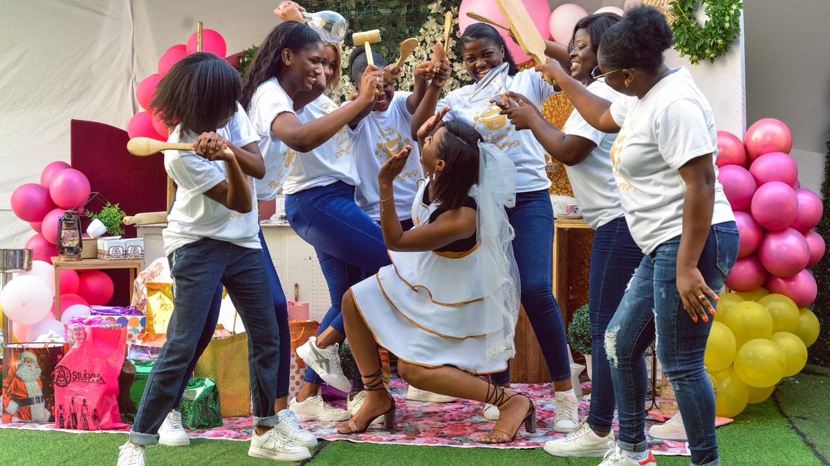 Joyful bridal party with friends gathering for bachelorette celebration outdoors, filled with laughter and playful antics.